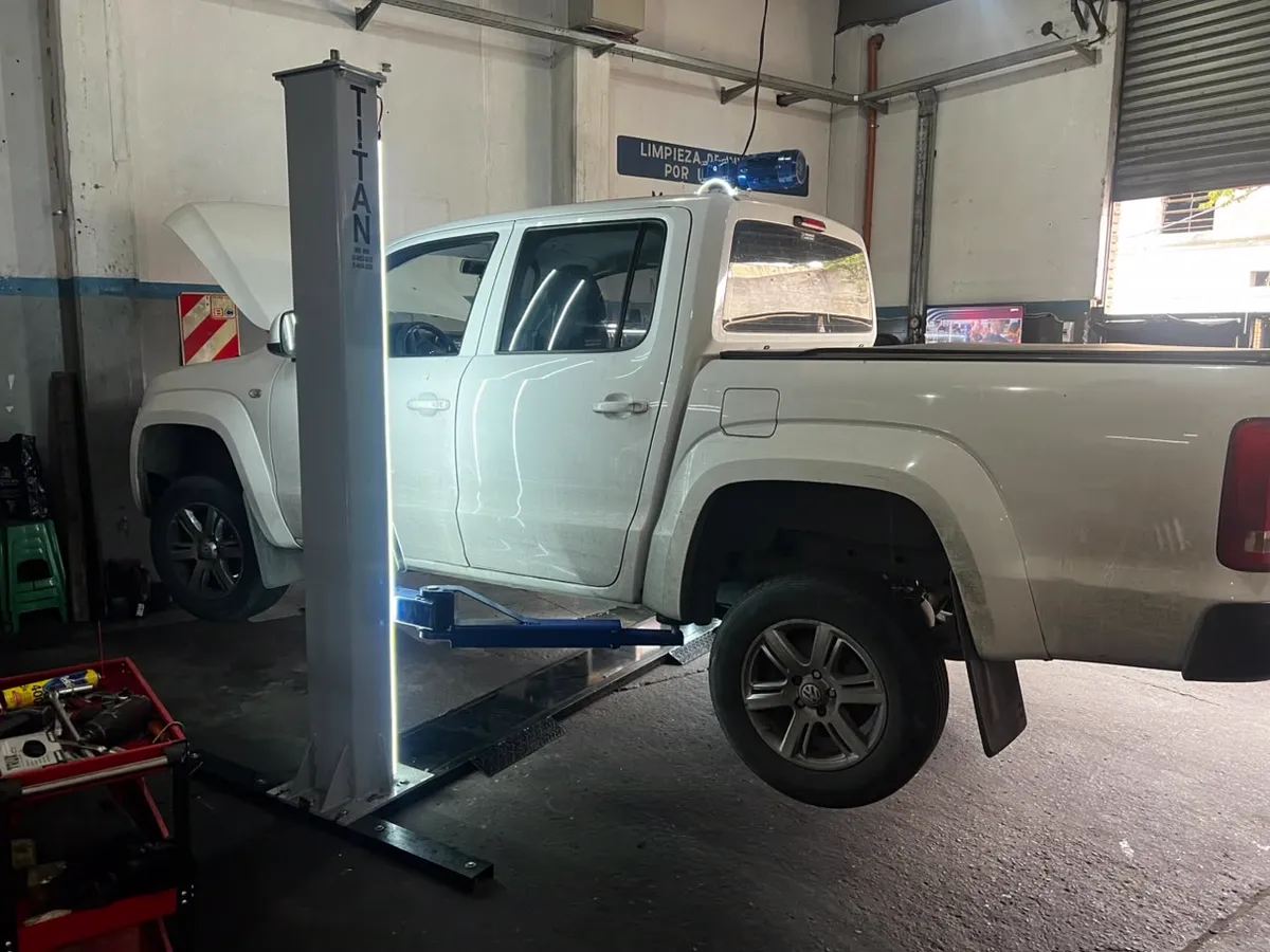 Camioneta Volkswagen Amarok sobre elevador de dos columnas en el taller